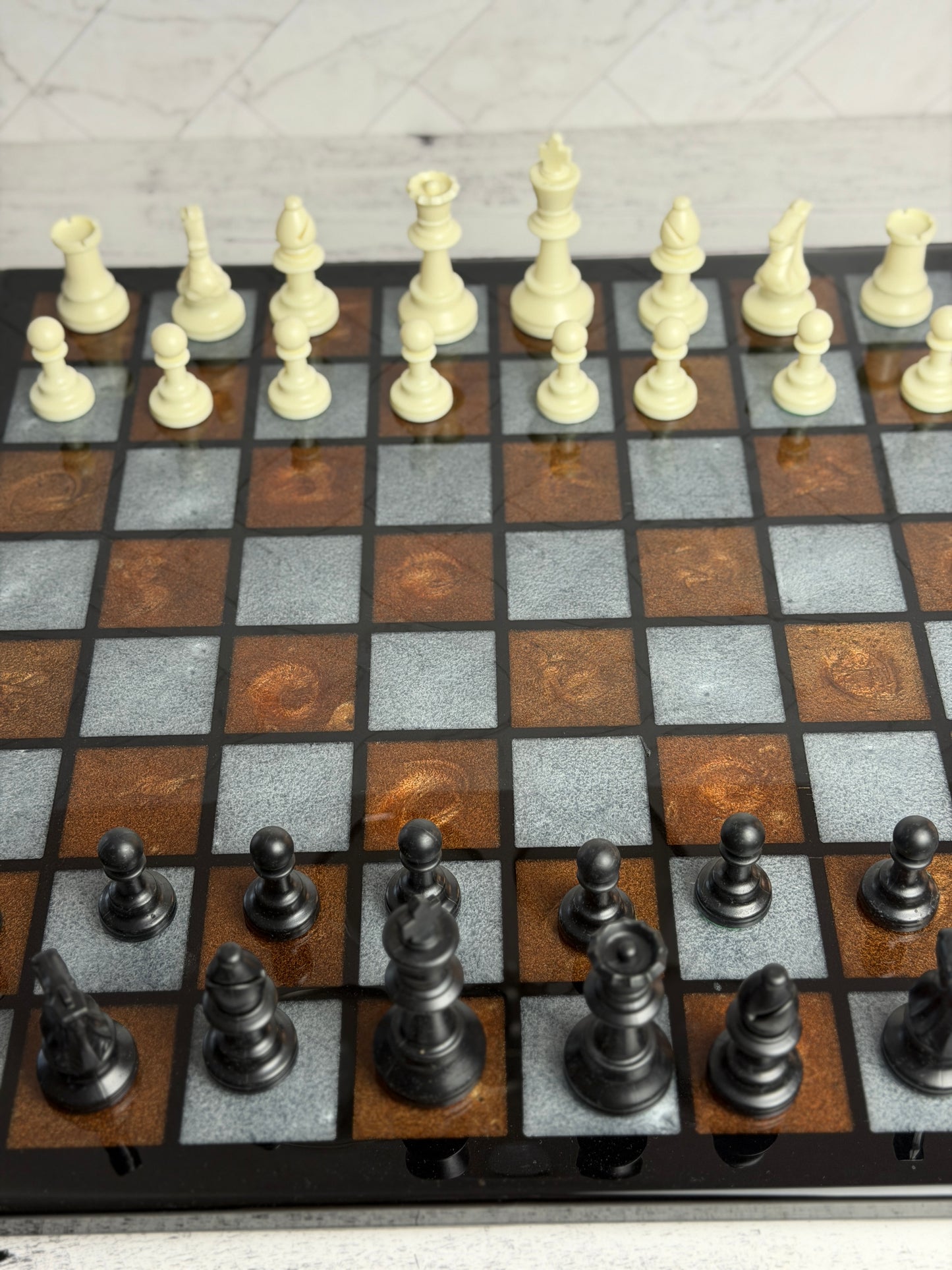 Handcrafted dark wood chess board with copper and gray epoxy resin squares, laser-engraved details, and full chess piece set — Bees Boards